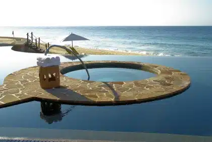 Vacationist enjoying a cold drink poolside at a tropical resort