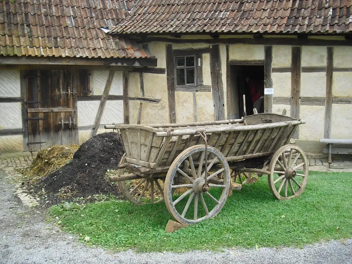 Empty farmhouse with vintage camcorder on tripod suggesting found-footage style