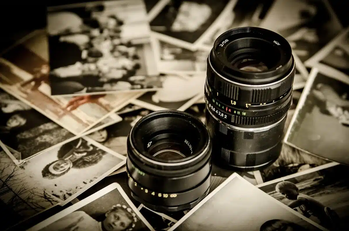 Hands holding a worn film script and vintage reels on a table in a sunlit office