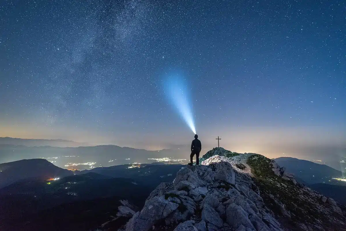 A remote reservoir at night with photos laid on the shore
