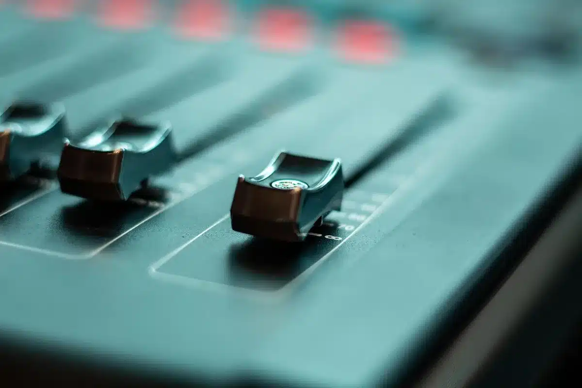 Close-up of a mixing console with faders and knobs in a studio