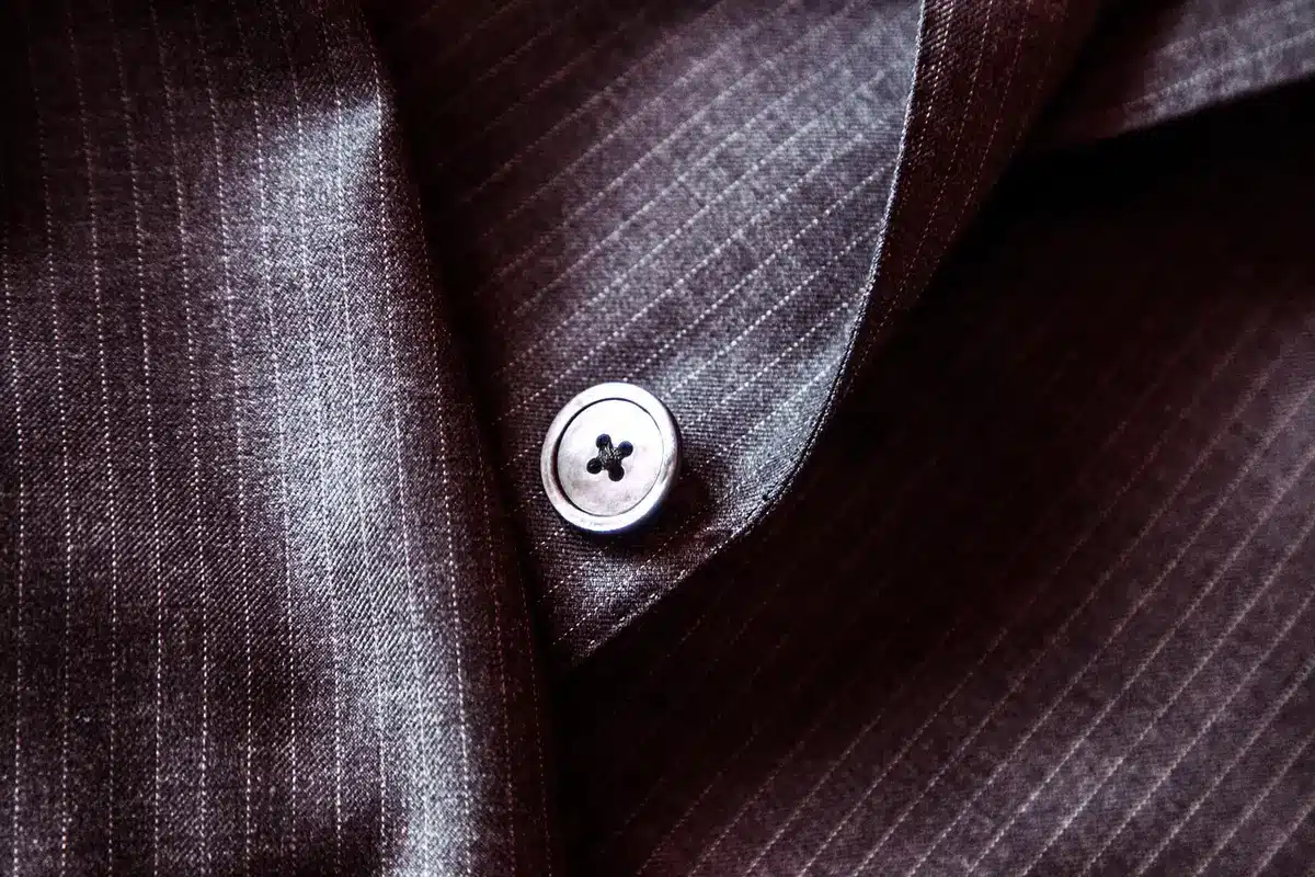 Detail of a white T‑shirt showing under a tailored blazer at a screening