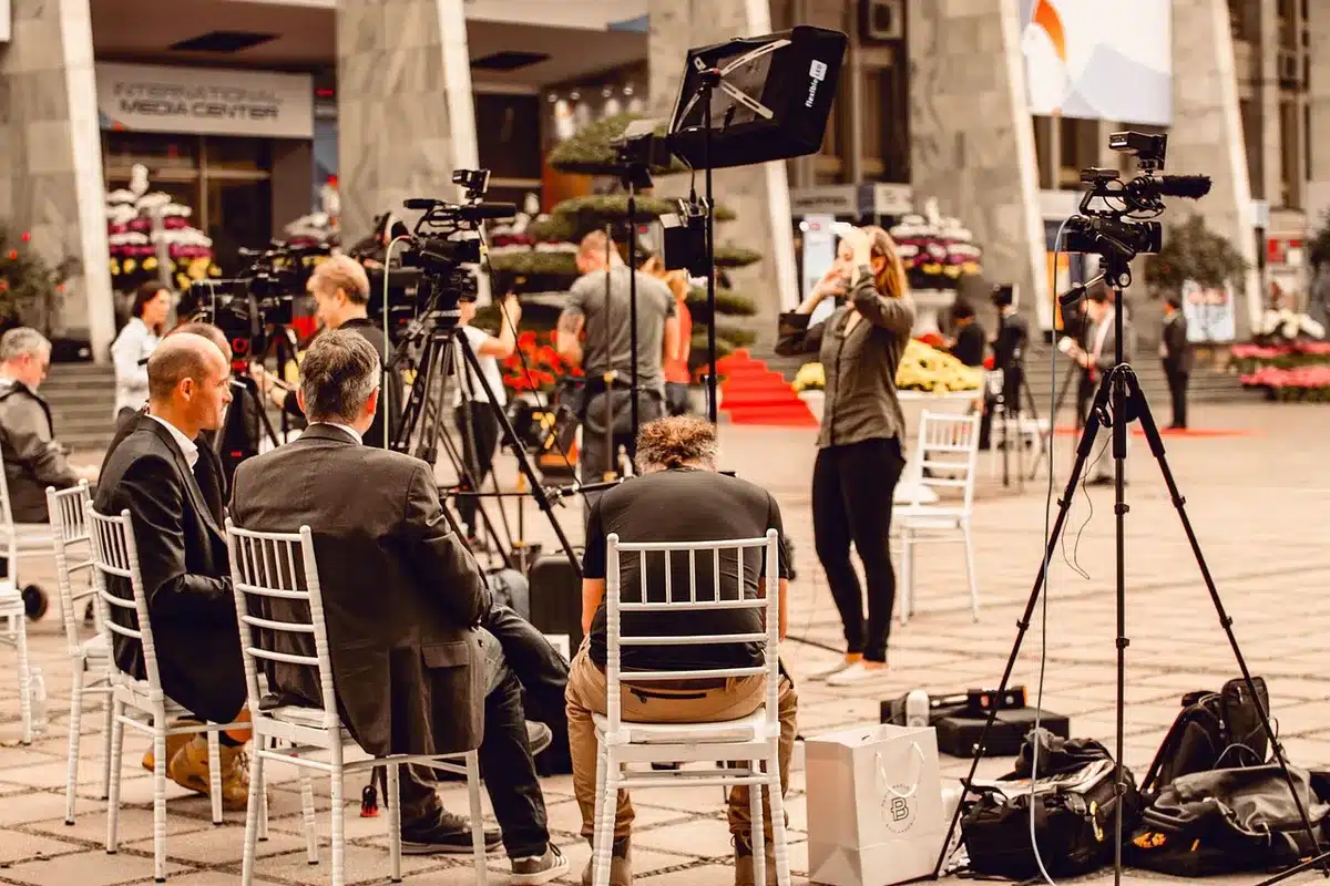 Blurred TV set with crew working under studio lights, evoking on-set tension