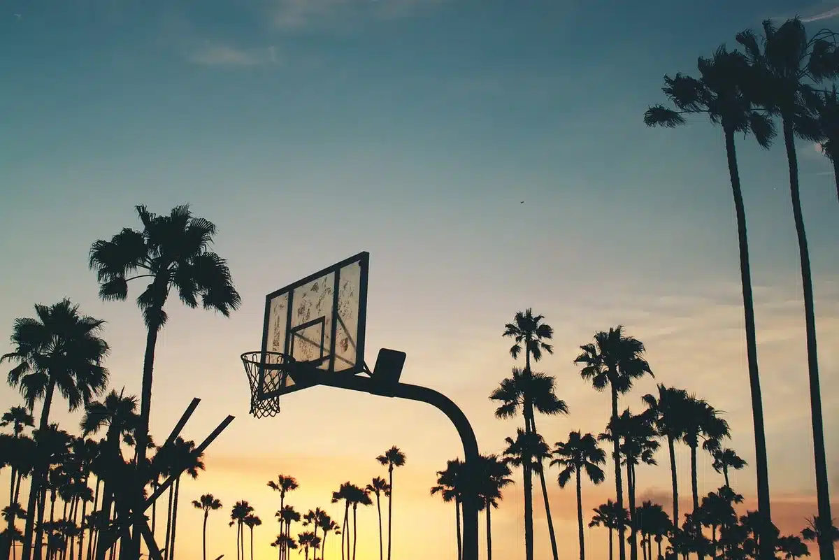 Silhouette of a player taking a contested three-point shot late in a game