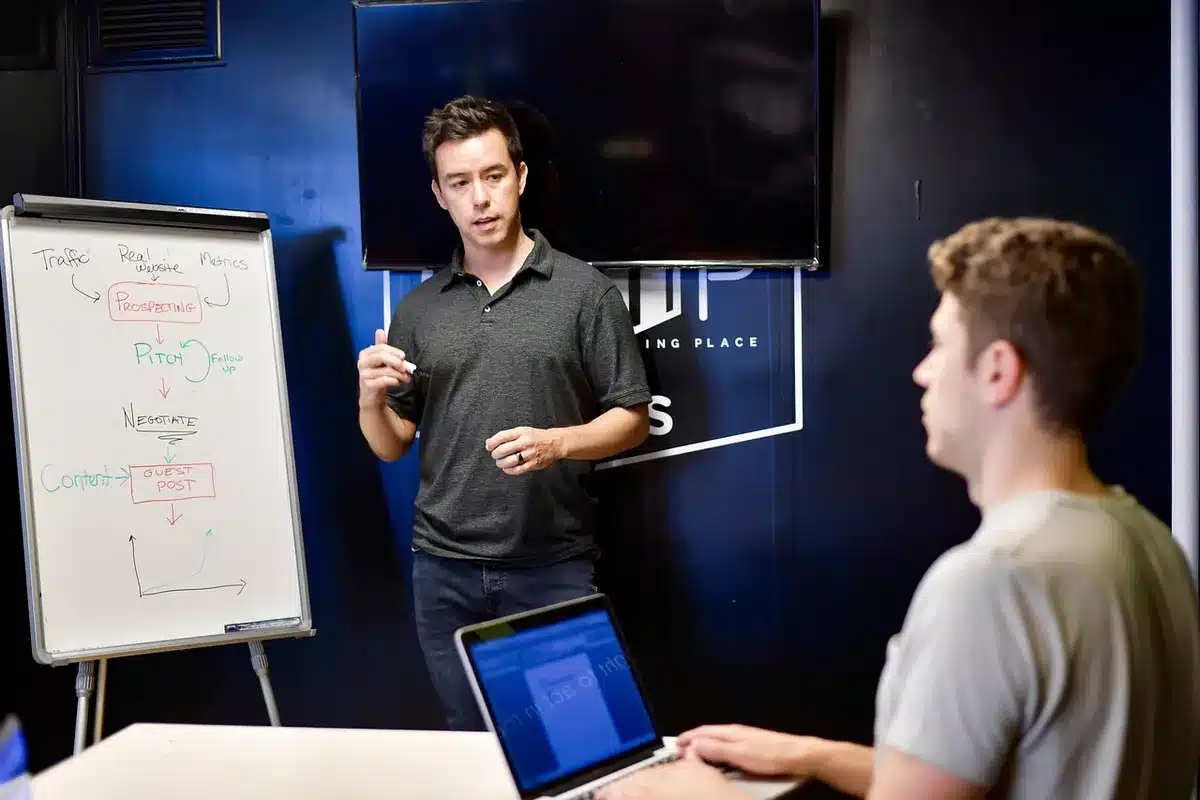 Coach pointing at a play on a whiteboard during a team meeting
