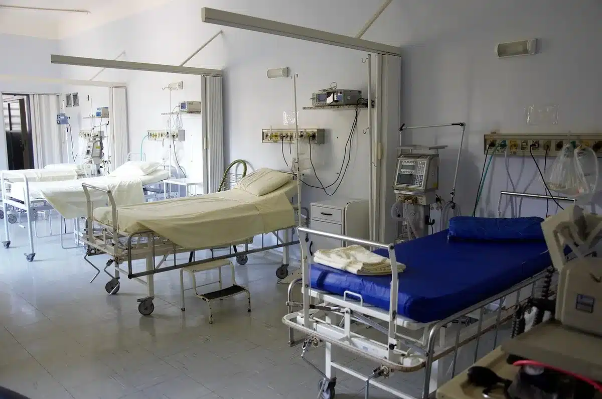Hospital bed and medical equipment suggesting postoperative recovery