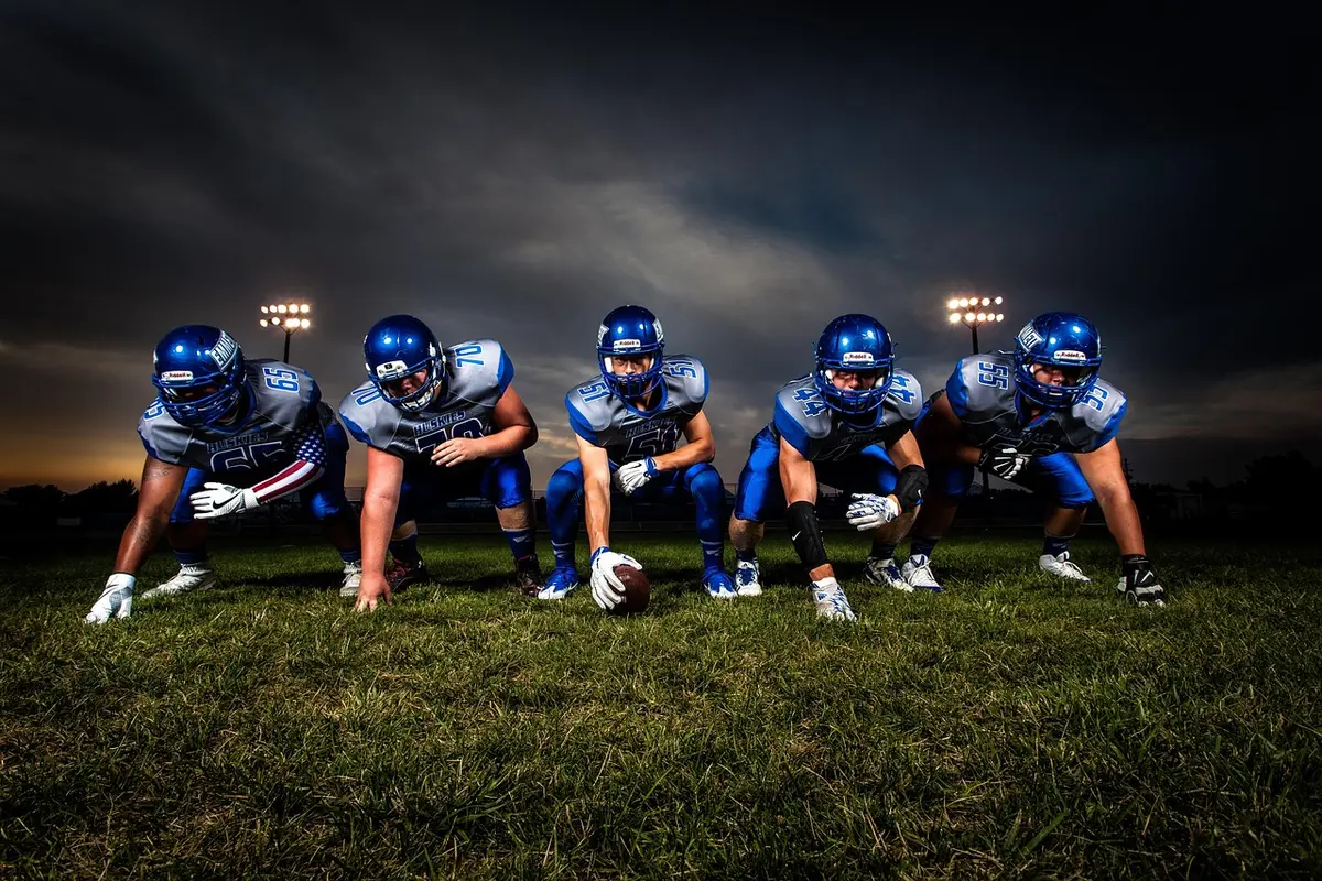 Defensive backs huddling on the sideline preparing for substitutions