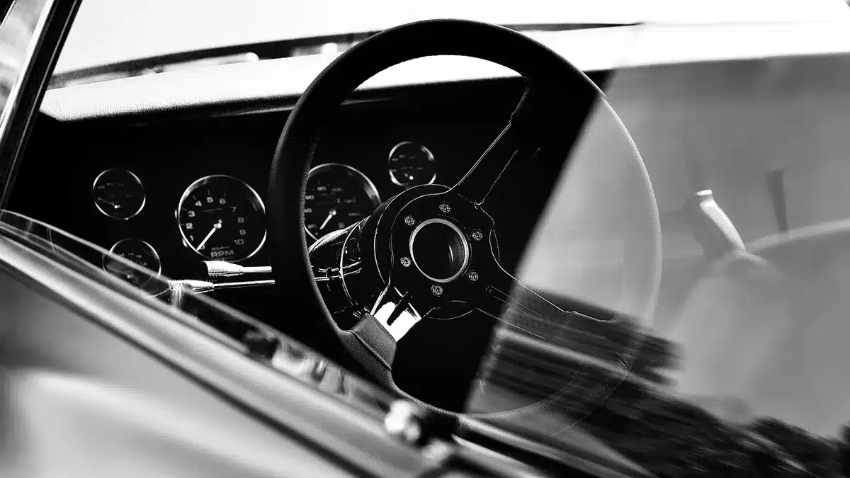 Hands on a steering wheel in traffic showing tension
