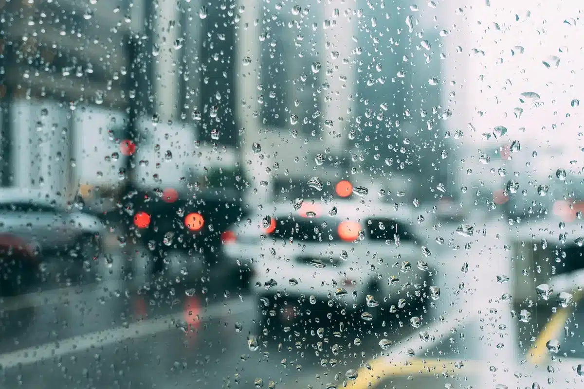 Dashboard view with a fuzzy keychain on a car key and blurred city traffic beyond