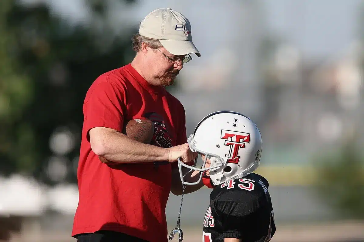 Quarterback and coach exchanging a sideline handshake