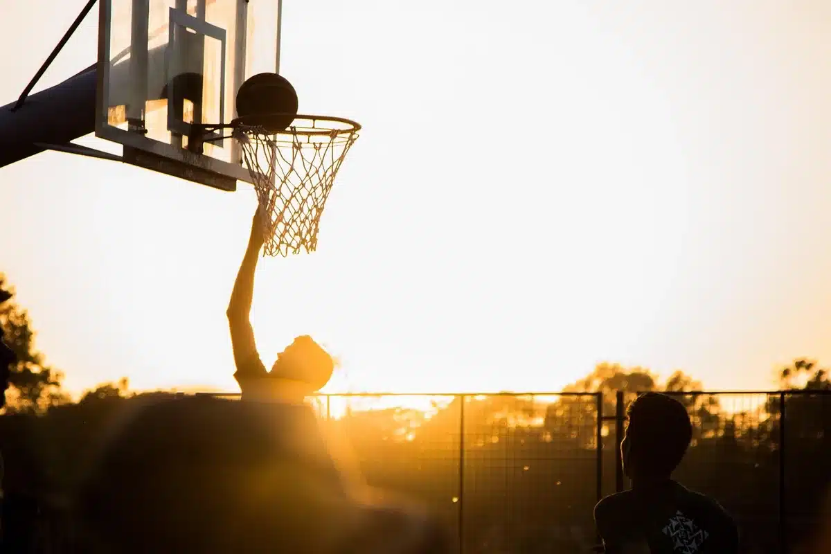 Silhouette of a guard with ball near teammates rotating on defense