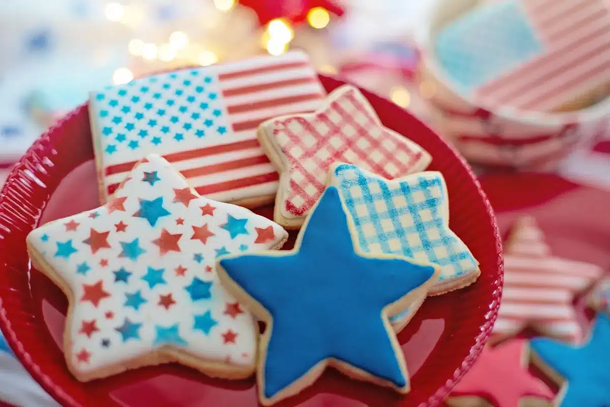 Person behind a cookie shop counter placing cookies in a tray