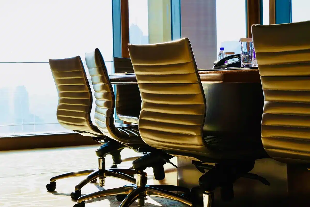 Silhouetted executives in a boardroom around a table during a strategy meeting