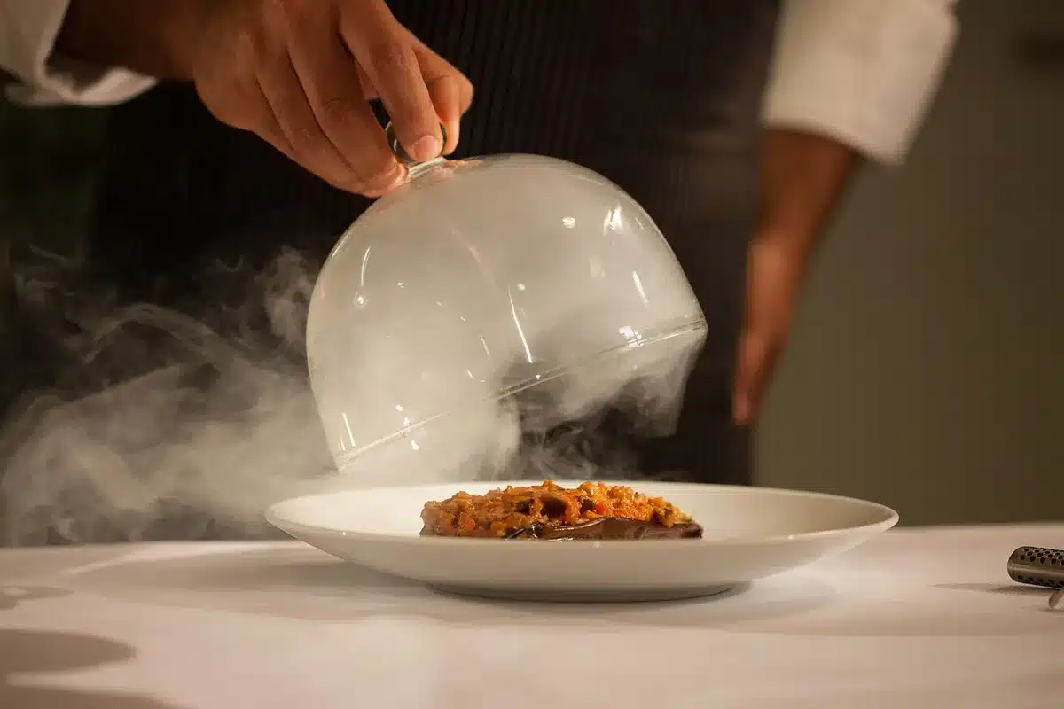 Chef preparing a plated tasting menu in a resort kitchen