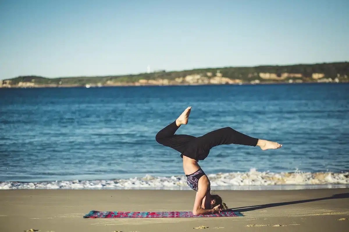 Person doing bodyweight exercises on the beach at sunset