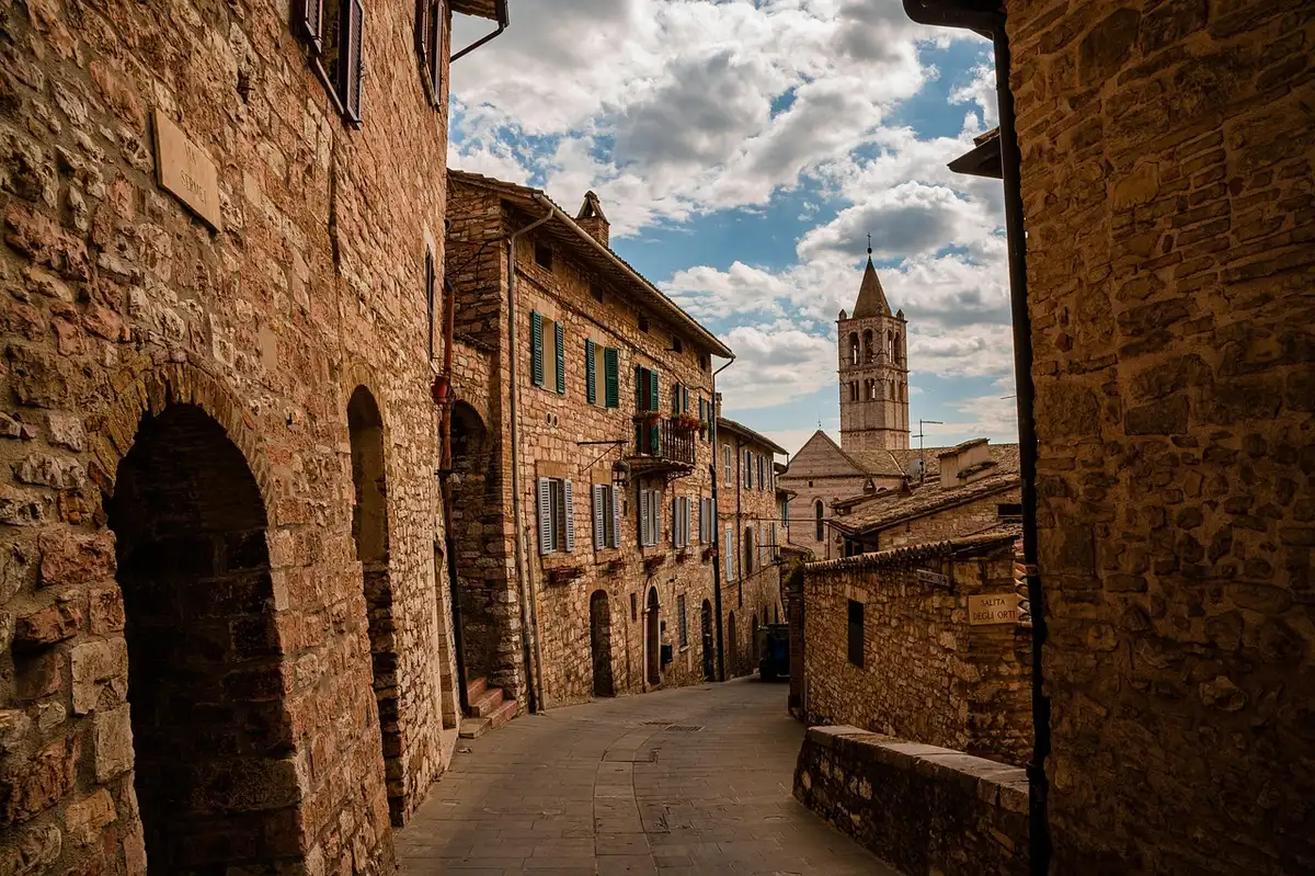 Waterfall running through a historic town center with stone buildings