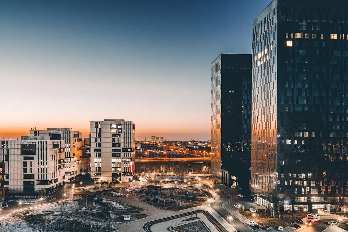 Hotel-window reflection showing city skyline and a faint human silhouette