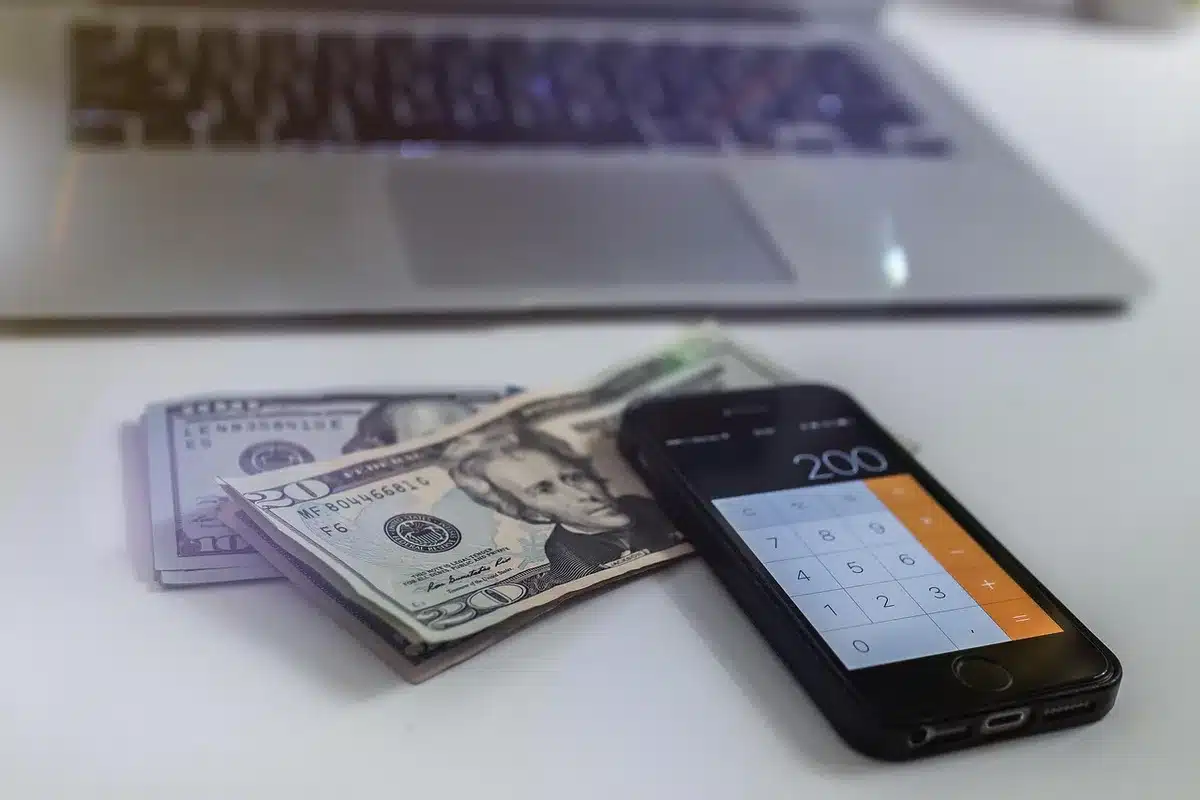 Traveler calculating travel spend with laptop and receipts