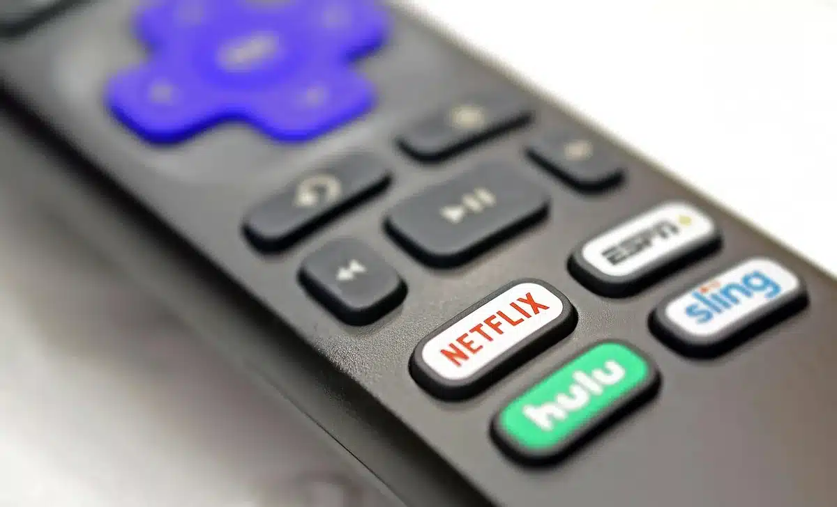 Remote control and streaming app icons on a TV showing sports menus