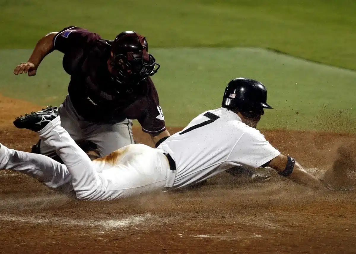 Batter mid-swing hitting a home run in a night game